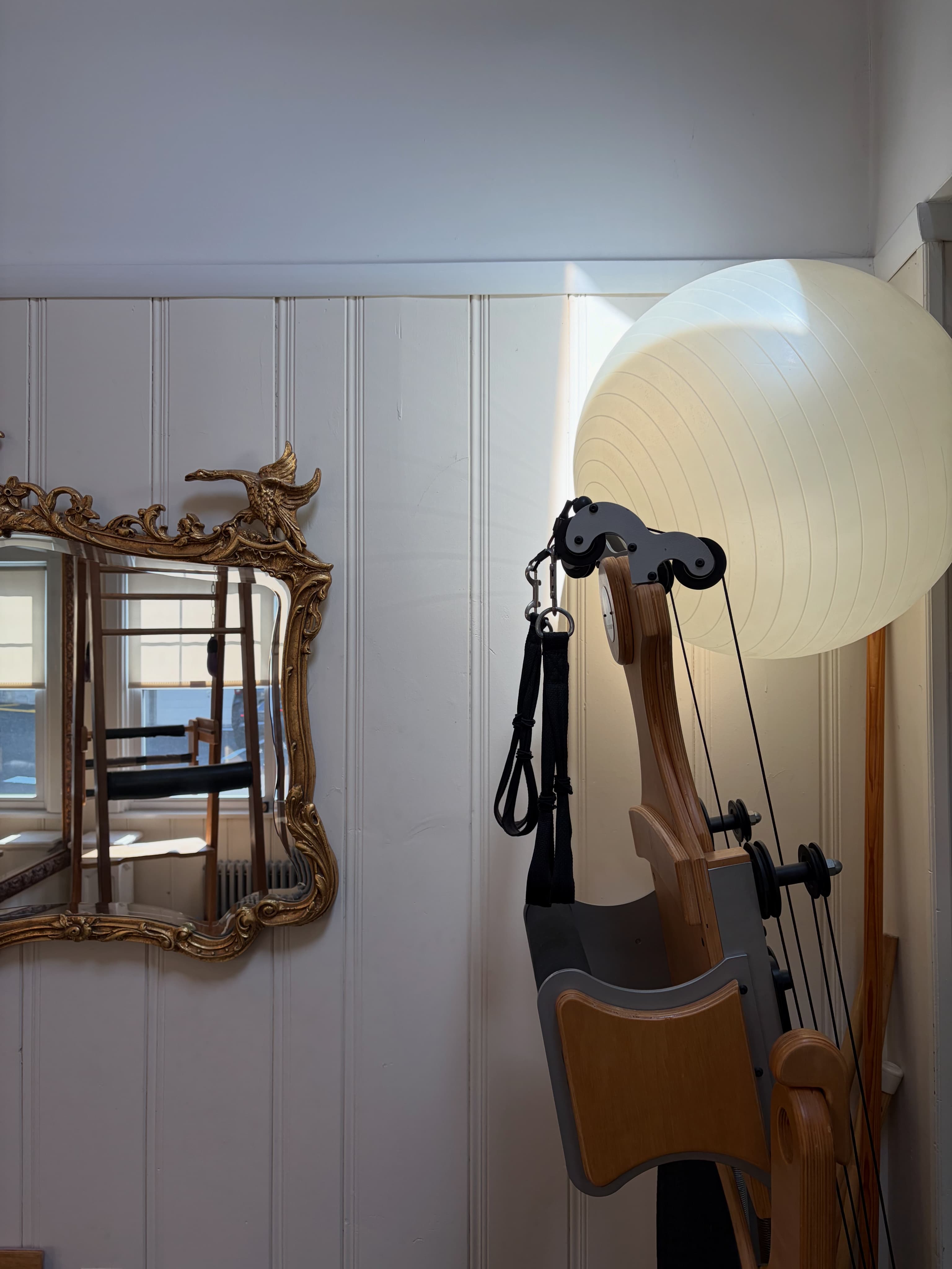 KRU Wellness studio — Gyrotonic equipment, natural light, ornate gold mirror